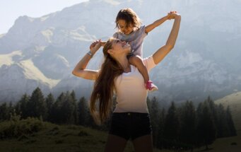 Ein Au-pair Mädchen mit einen Kind in den Bergen